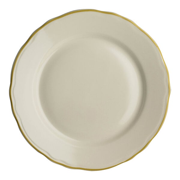 A close-up of a Homer Laughlin white china plate with a gold scalloped rim.