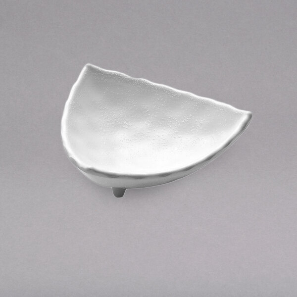 A white triangular Elite Global Solutions melamine sauce cup.