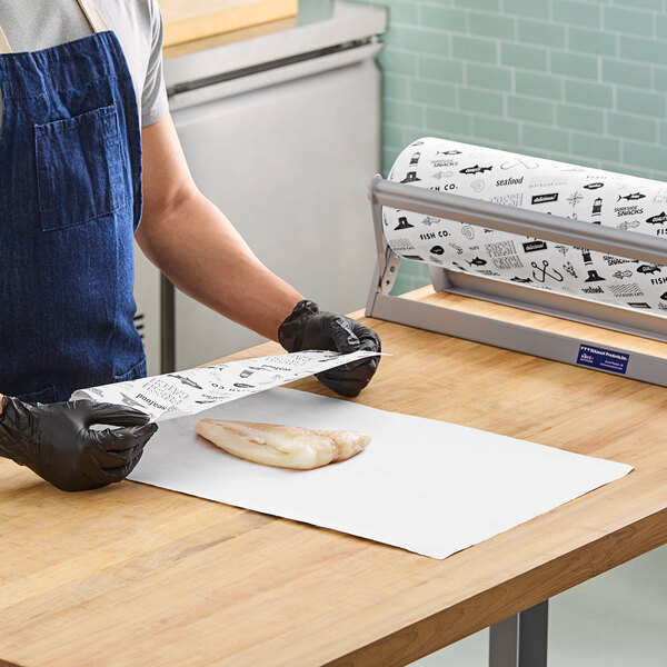 A person in a blue apron and gloves cutting fresh fish on a counter.