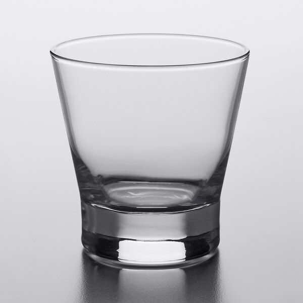 A clear Libbey rocks glass on a white surface.