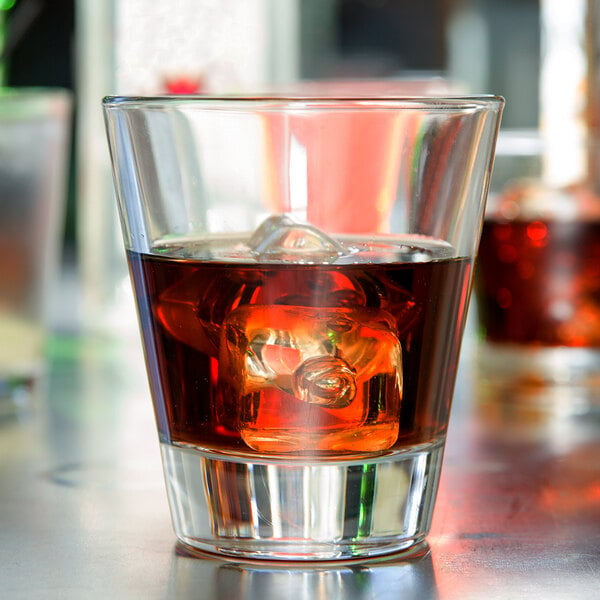 A Libbey Elan Rocks glass filled with brown liquid and ice cubes.