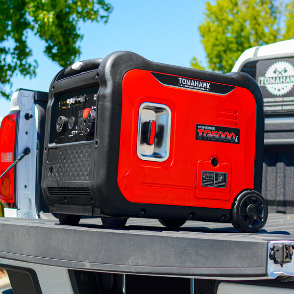 A red and black Tomahawk portable inverter generator on a table in an outdoor catering setup.