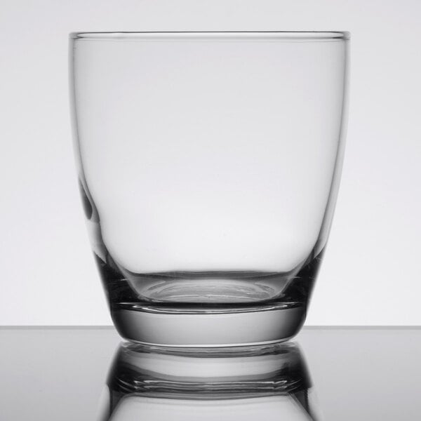 A close up of a Libbey Embassy clear rocks glass on a reflective surface.