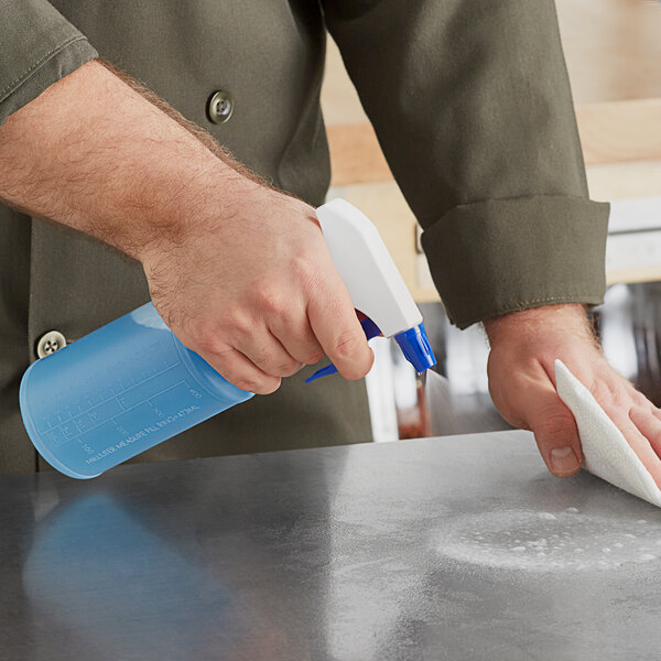 A person using a Lavex spray bottle to clean a counter.