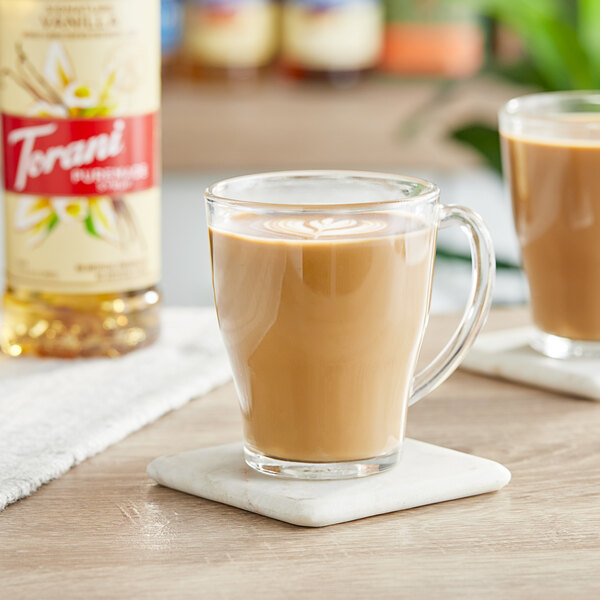 A glass of Torani vanilla-flavored coffee on a coaster.