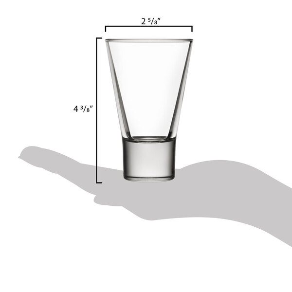A hand holding a Libbey tall shot glass.