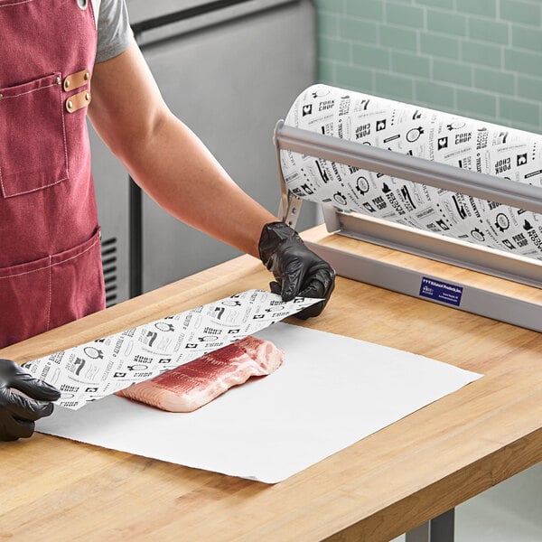 A person in a red apron and black gloves wrapping meat with Choice barbecue print butcher paper.