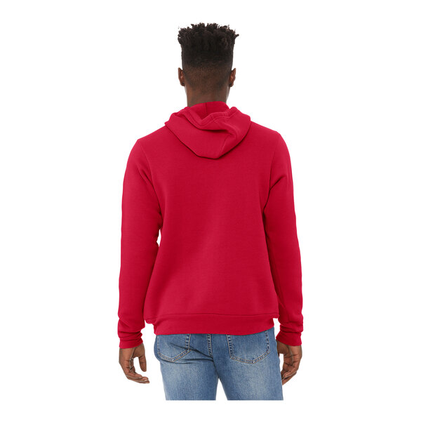 A man wearing a red Bella + Canvas sponge fleece hoodie with his hands on his hips.