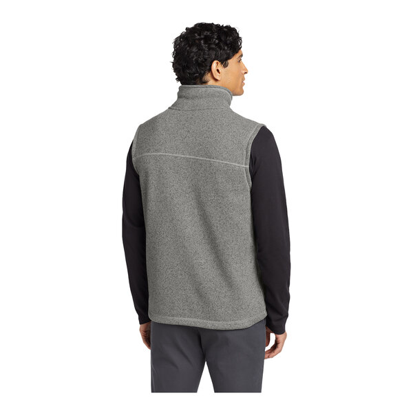 A man wearing a medium gray The North Face fleece vest.