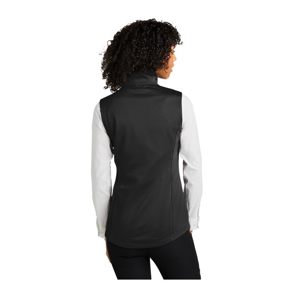 A woman wearing a deep black Port Authority fleece vest.