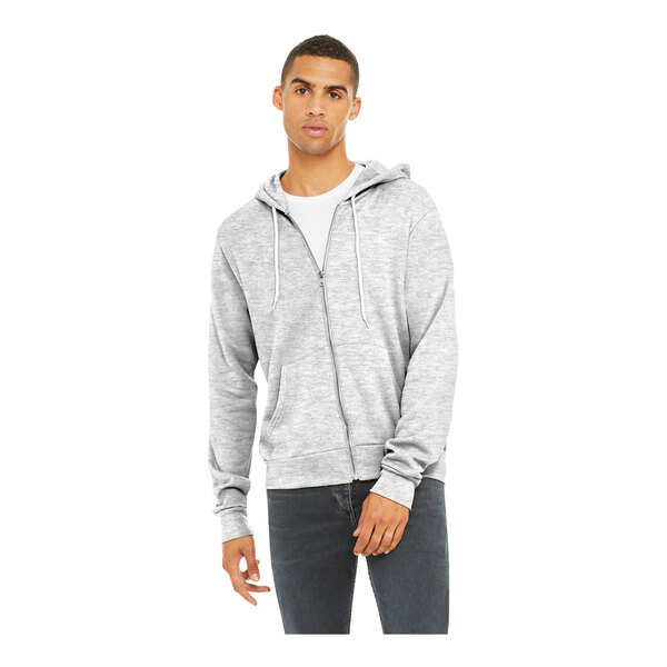 A man wearing a grey zip up Bella + Canvas sweatshirt.