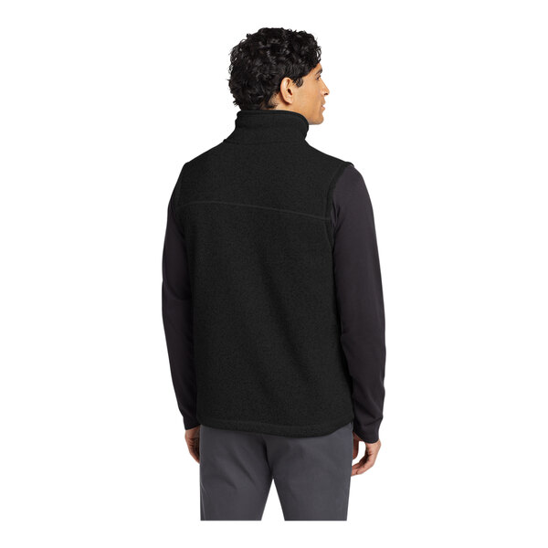 A man wearing a black The North Face fleece vest.