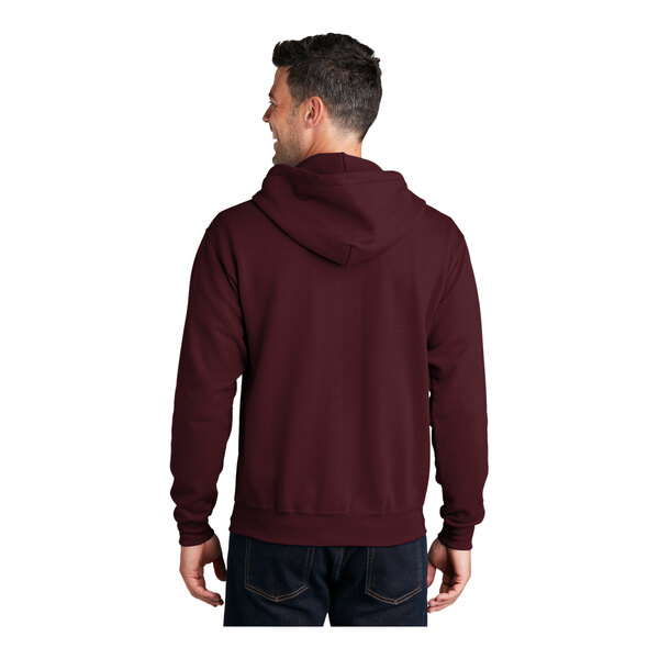 A man wearing a maroon Port & Company full-zip hoodie with the hood up.