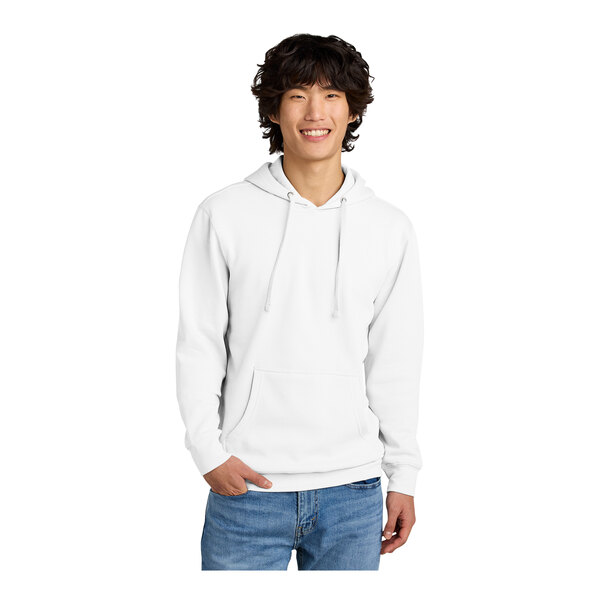 A man wearing a white District sweatshirt with a hood.