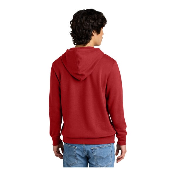 A man wearing a red sweatshirt with a hood.