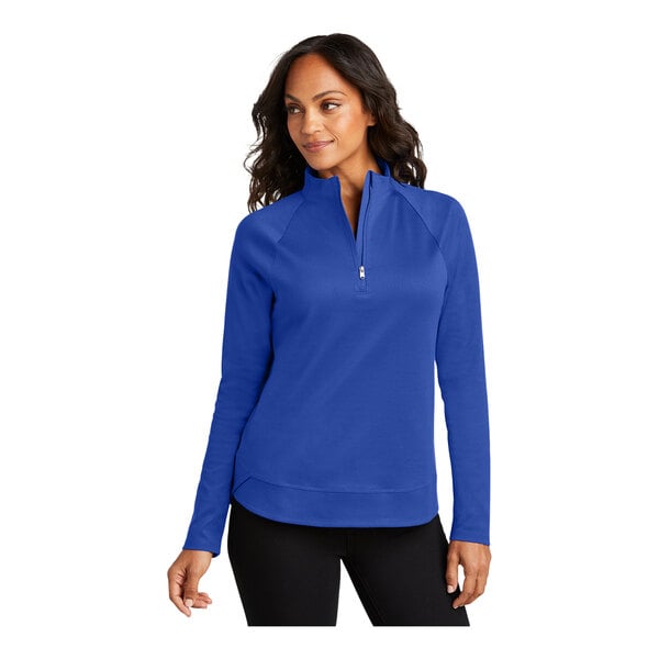 A woman wearing a Port Authority True Royal quarter-zip sweatshirt.