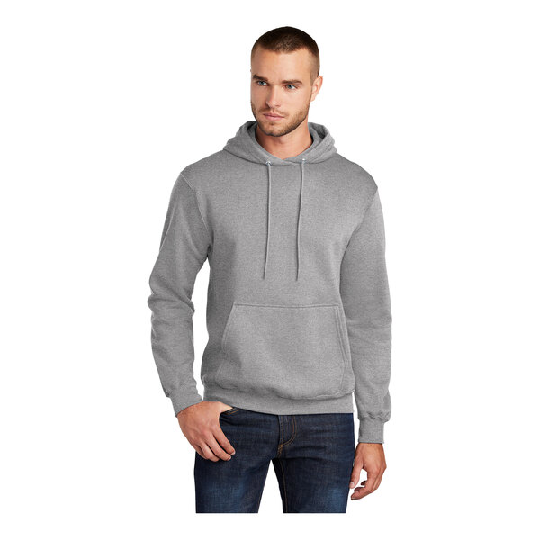 A man wearing a Port & Company Athletic Heather Core Fleece pullover hoodie with a drawstring.