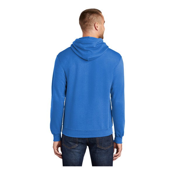 A person wearing a royal blue Port & Company Core Fleece pullover hoodie.