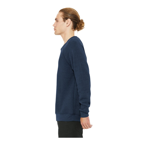 A man in a Bella + Canvas heather navy blue raglan crewneck sweatshirt with his hands on his hips.