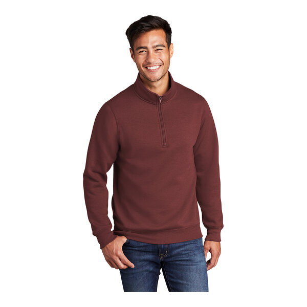 A man wearing a maroon Port & Company quarter-zip pullover.