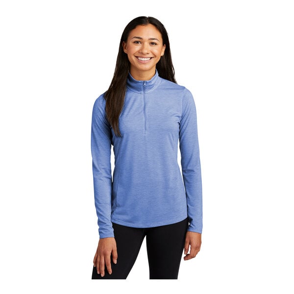 A woman wearing a Sport-Tek blue long sleeve pullover with a quarter-zip.