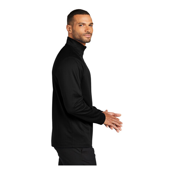 A person wearing a black Port Authority quarter-zip sweatshirt.