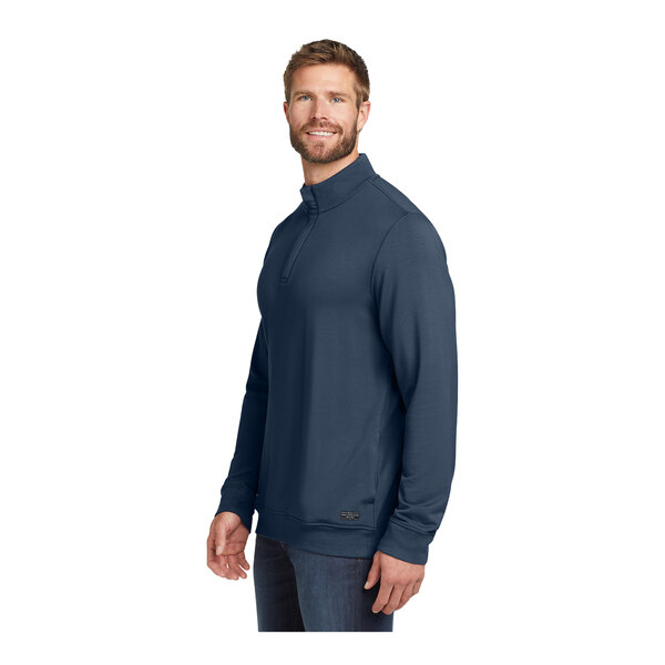 A man wearing a TravisMathew blue fleece 1/4 zip pullover.