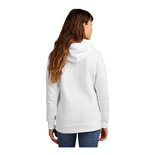 A woman wearing a white Port & Company core fleece pullover hoodie.