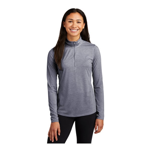 A woman wearing a Sport-Tek True Navy Heather quarter-zip pullover with a grey shirt underneath.