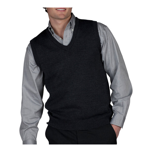 A man wearing a charcoal jersey knit vest over a shirt is smiling.