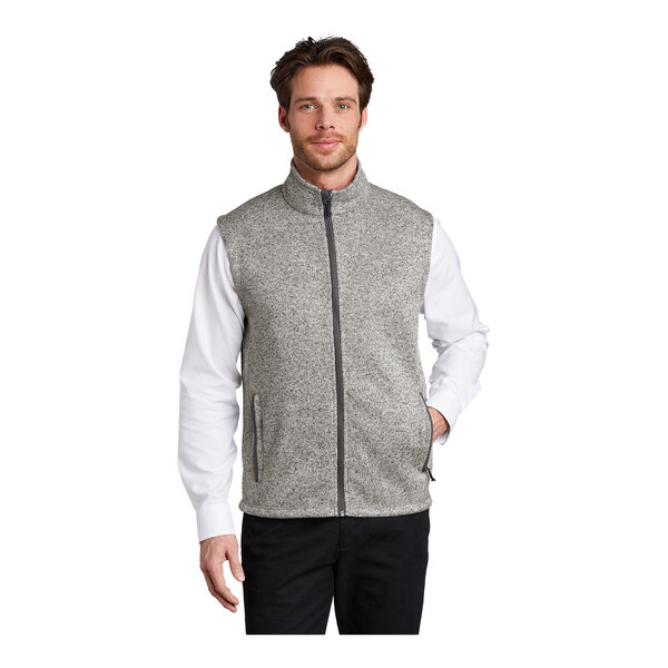 A man wearing a gray fleece Port Authority sweater vest with a zipper.