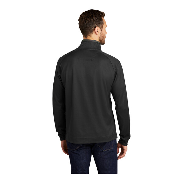A man wearing a black Port Authority quarter-zip pullover sweater with iron gray accents.