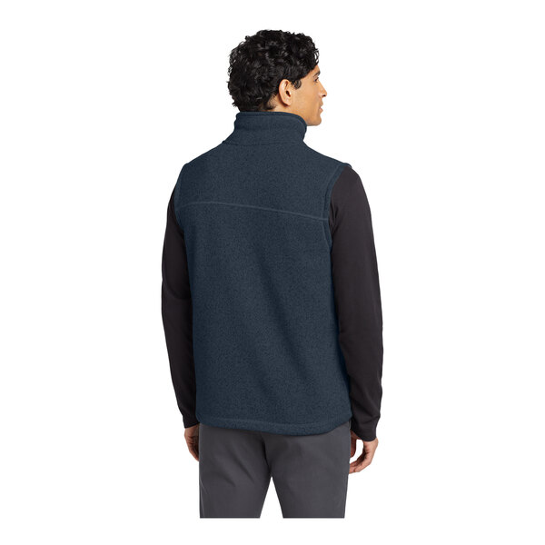 A man wearing a navy The North Face fleece vest.