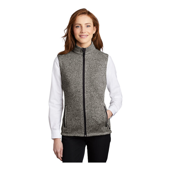 A woman wearing a gray Port Authority fleece sweater vest.