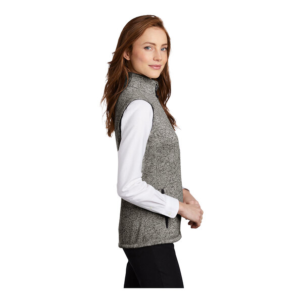A woman wearing a gray Port Authority fleece sweater vest.