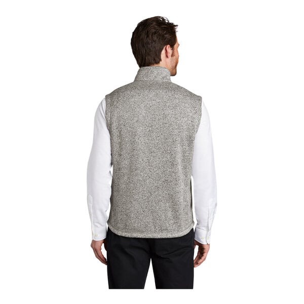 A man wearing a gray fleece sweater vest with a zipper closure.