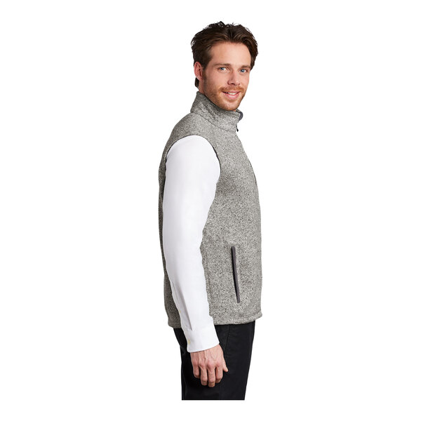 A man wearing a gray fleece sweater vest with a zipper.