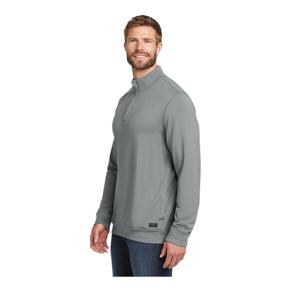 A man wearing a TravisMathew grey fleece quarter-zip pullover.