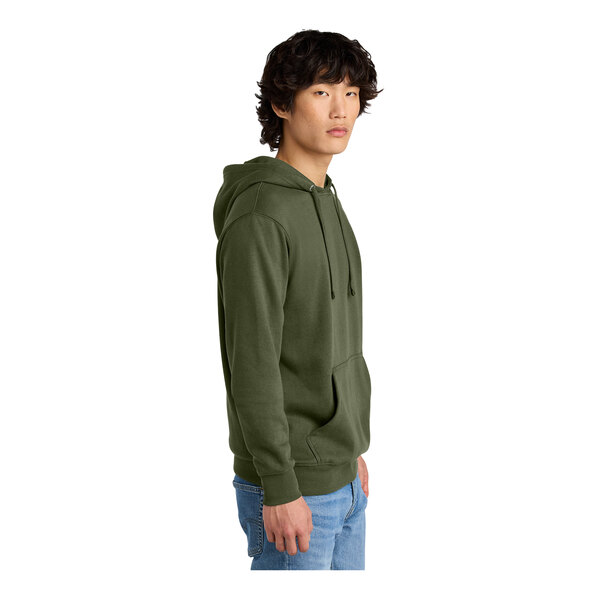A person wearing a green District hoodie with a zipper.