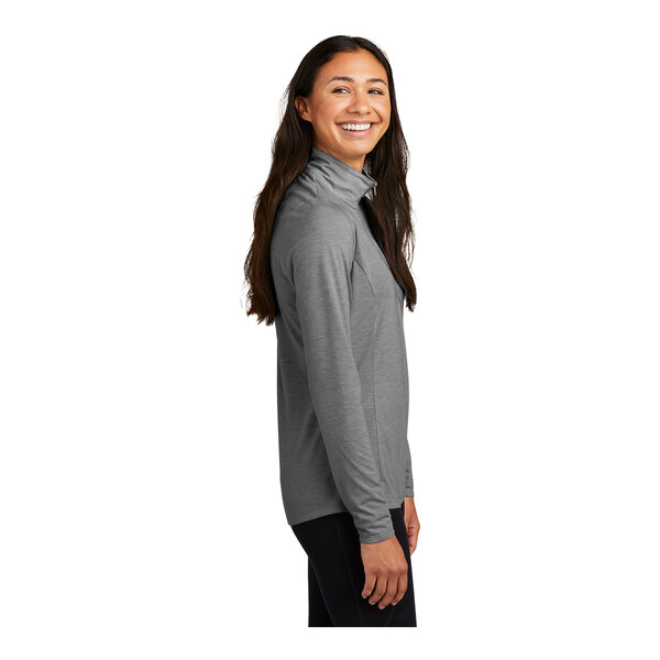 A woman wearing a Sport-Tek dark gray PosiCharge quarter-zip pullover.