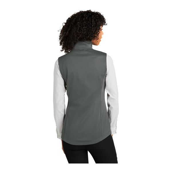 A woman wearing a graphite Port Authority fleece vest.