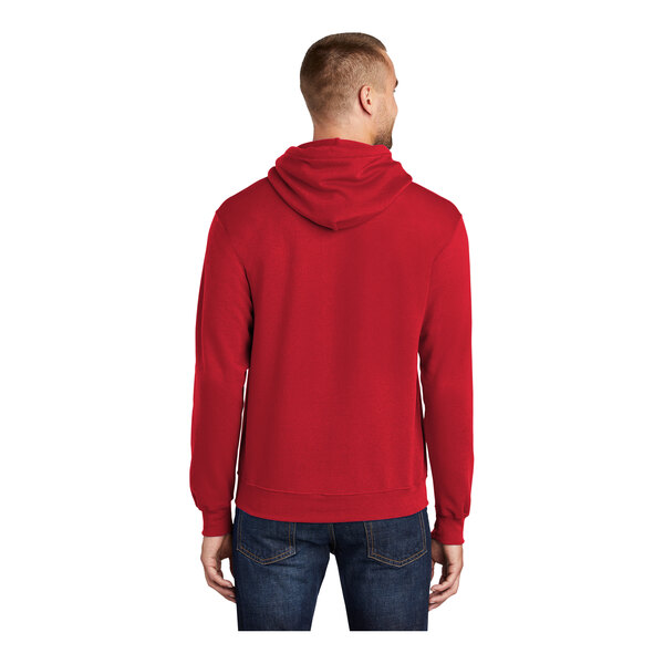 A man wearing a red Port & Company Core Fleece pullover hoodie.