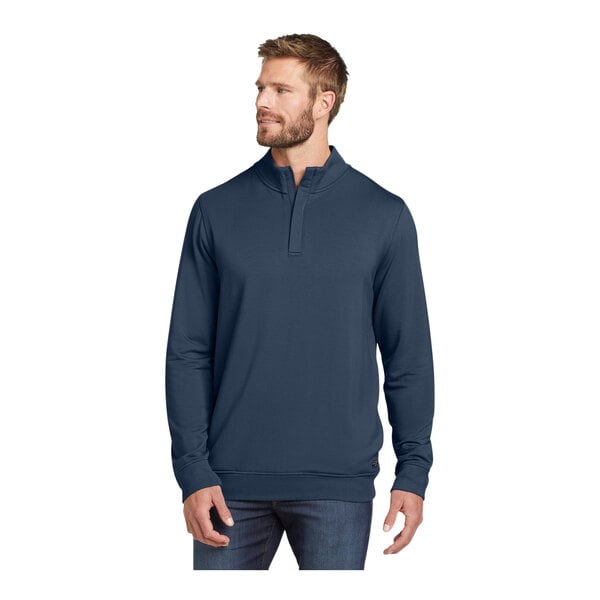 A man wearing a TravisMathew blue fleece quarter-zip pullover.