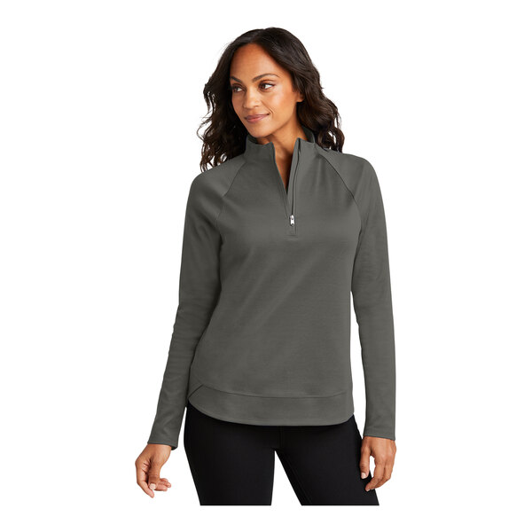 A woman wearing a Port Authority grey 1/4 zip sweatshirt.