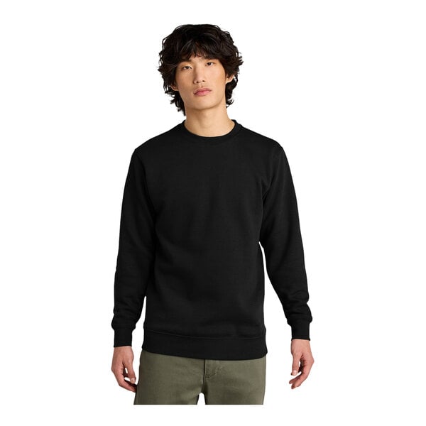 A man wearing a black District fleece crewneck sweatshirt.