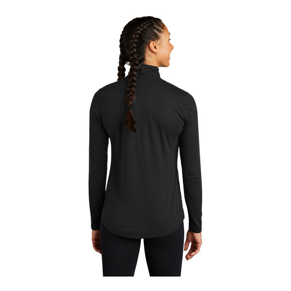 A woman wearing a black Sport-Tek Triad quarter-zip pullover with braided hair.