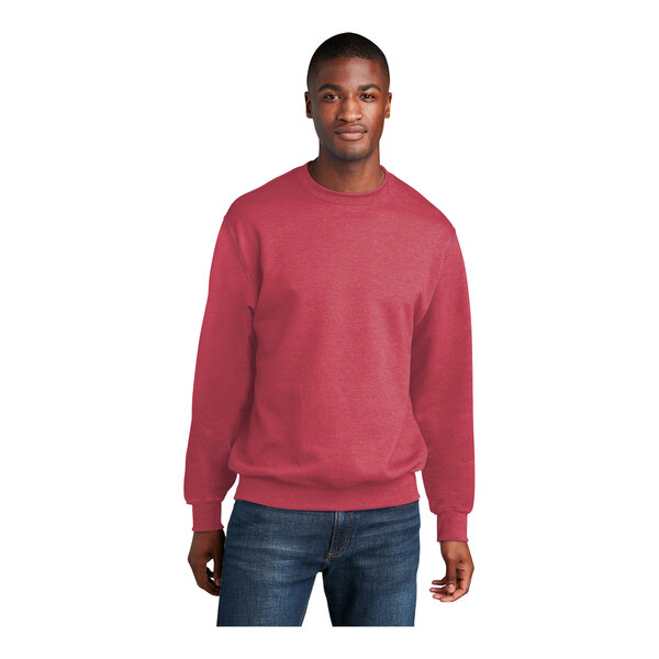 A man wearing a heather red Port & Company core fleece crewneck sweatshirt.