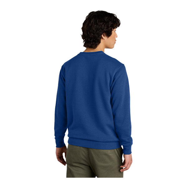 A man wearing a District deep royal blue fleece crewneck sweatshirt.