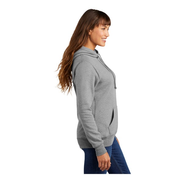 A woman in a Port & Company athletic heather fleece pullover hoodie.
