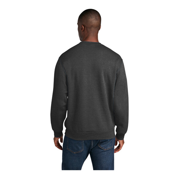 A man wearing a dark heather grey Port & Company core fleece sweatshirt.